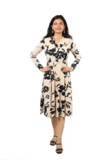 Woman wearing a beige and black floral midi dress, front view, standing and smiling