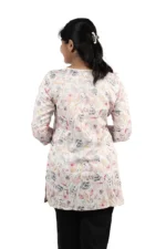 Woman showing the back view of a white floral printed kurti with black pants, hair tied back