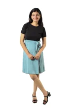 Woman in a black top and light blue skirt, angled front view, relaxed pose
