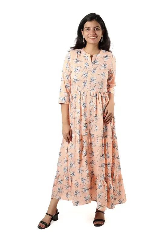 Woman wearing a peach floral maxi dress, front view, standing and smiling