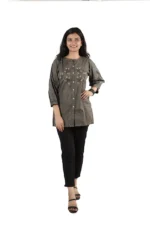 Woman wearing a grey embroidered kurti with black pants, front view, standing and smiling