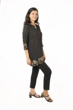Woman in a black kurti with elephant print, side view, smiling