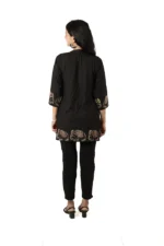 Woman showing the back view of a black kurti with elephant print, three-quarter sleeves