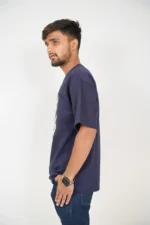 Man in navy blue t-shirt and denim posed from left side