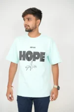 Man wearing mint green t-shirt and jeans facing forward