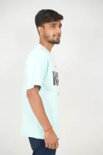 Male model wearing mint green t-shirt in right-side profile