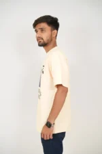 Man in beige t-shirt and jeans shown from left side