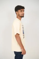 Man wearing casual beige t-shirt and denim, posed from right side