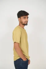 Man wearing mustard yellow t-shirt standing in right side view