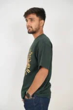Man in dark green t-shirt posing from left side angle