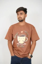 Man wearing brown oversized t-shirt and jeans, front-facing view