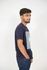 Man standing in right side pose wearing basic navy blue t-shirt