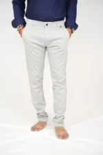 Man wearing white formal trousers and blue shirt, front view, hands in pockets