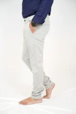 Man in white formal trousers and blue shirt, left side view, hand in pocket