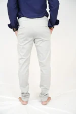 Man in white formal trousers and blue shirt, back view, hands in pockets