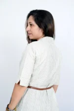 Rear view of woman wearing striped beige midi shirt dress
