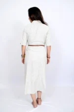 Side profile of woman wearing striped beige dress with belt