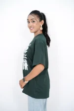 Woman standing in left side view wearing dark green t-shirt and jeans