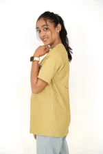 Woman modeling mustard yellow t-shirt from left side position