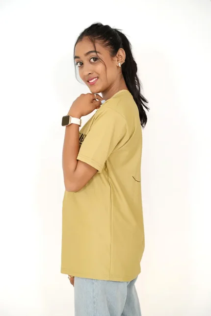 Woman modeling mustard yellow t-shirt from left side position