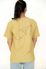 Rear view of woman in mustard yellow oversized t-shirt and jeans