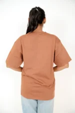 Back view of woman in plain brown oversized t-shirt
