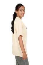 Female in beige casual t-shirt posing from left side