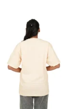 Back view of woman wearing oversized beige tee