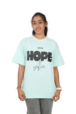 Woman in mint green casual t-shirt and grey jeans smiling frontally